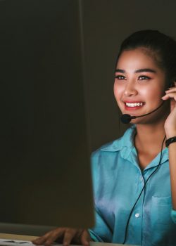 Asian Female customer care service smiling and working hard late in night shift